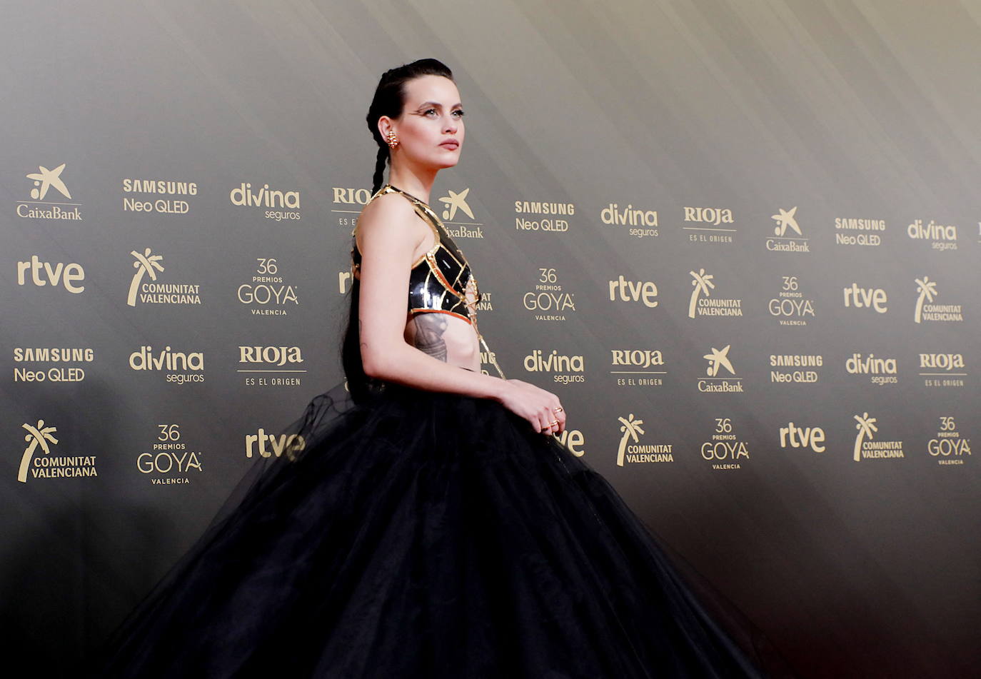 Milena Smit ha optado por un espectacular vestido negro de corte princesa firmado por Balmain, y diseñado por y para ella a medida, con transparencias y detalles en negro. Las joyas han sido obra de Cartier y los zapatos de Aquazzura