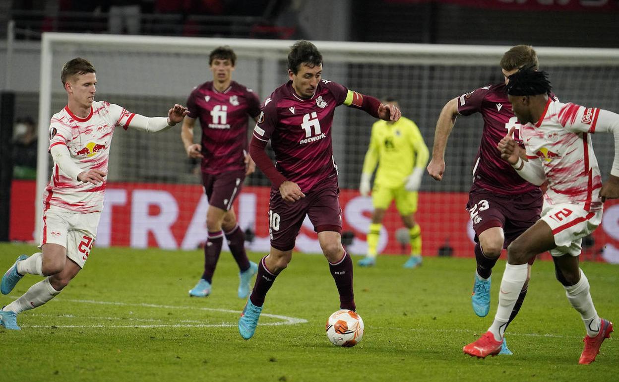 Oyarzabal conduce el balón en el partido de ida en Alemania ante la presencia de los jugadores del RB Leipzig Dani Olmo y Simakan.