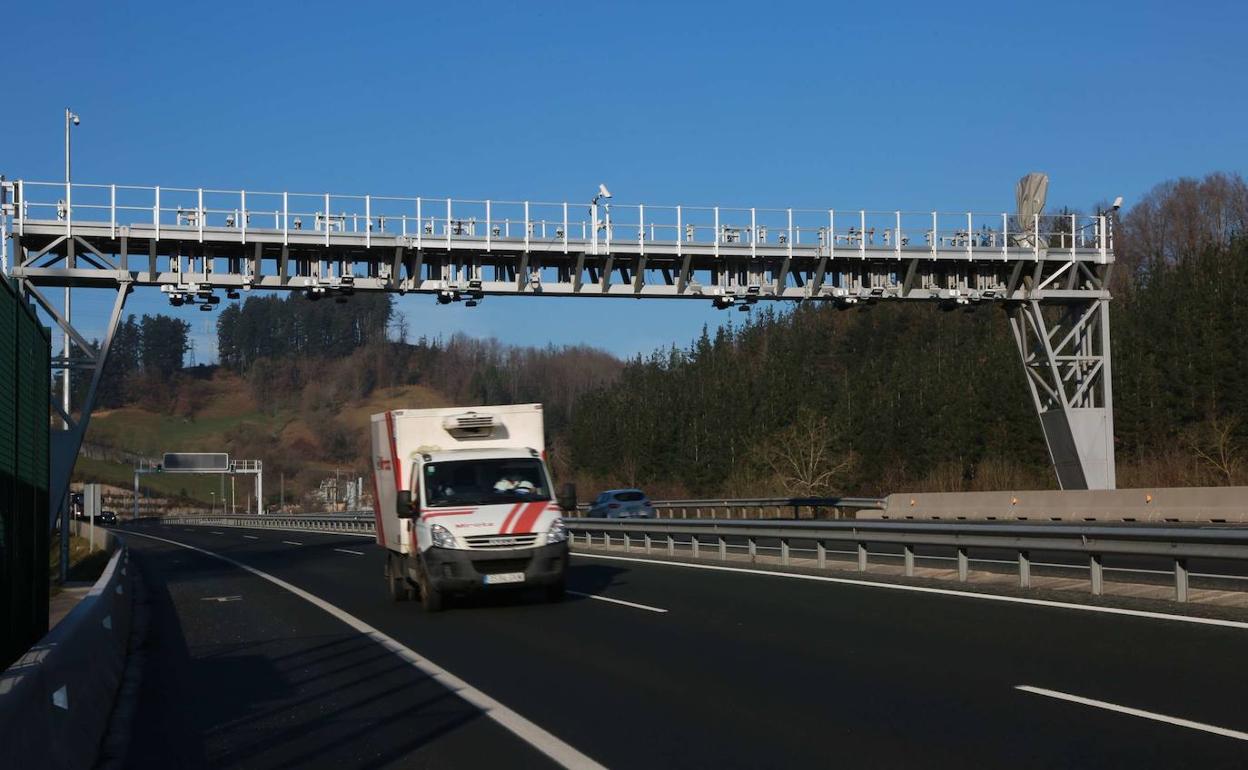 Un camión pasa bajo un arco de peaje. 