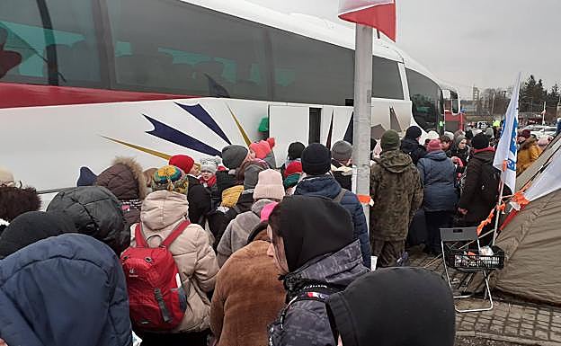 Imagen principal - Un autobús llega al campo de refugiados organizado en Przemysl para evacuar a medio centenar de ucranianos. La mayoría son mujeres, niños y niñas. Una mochila es todo su equipaje. Benito Escat y Olivia Fernández, en los extremos, cobijaron en su autocaravana 'maternal' a Elena, Sasha, Sofia y Ania antes de venir a Gipuzkoa. el puesto de comida de la ONG World Central Kitchen del cocinero José Andrés, que en 2020 recibió el Basque Culinary World Prize..