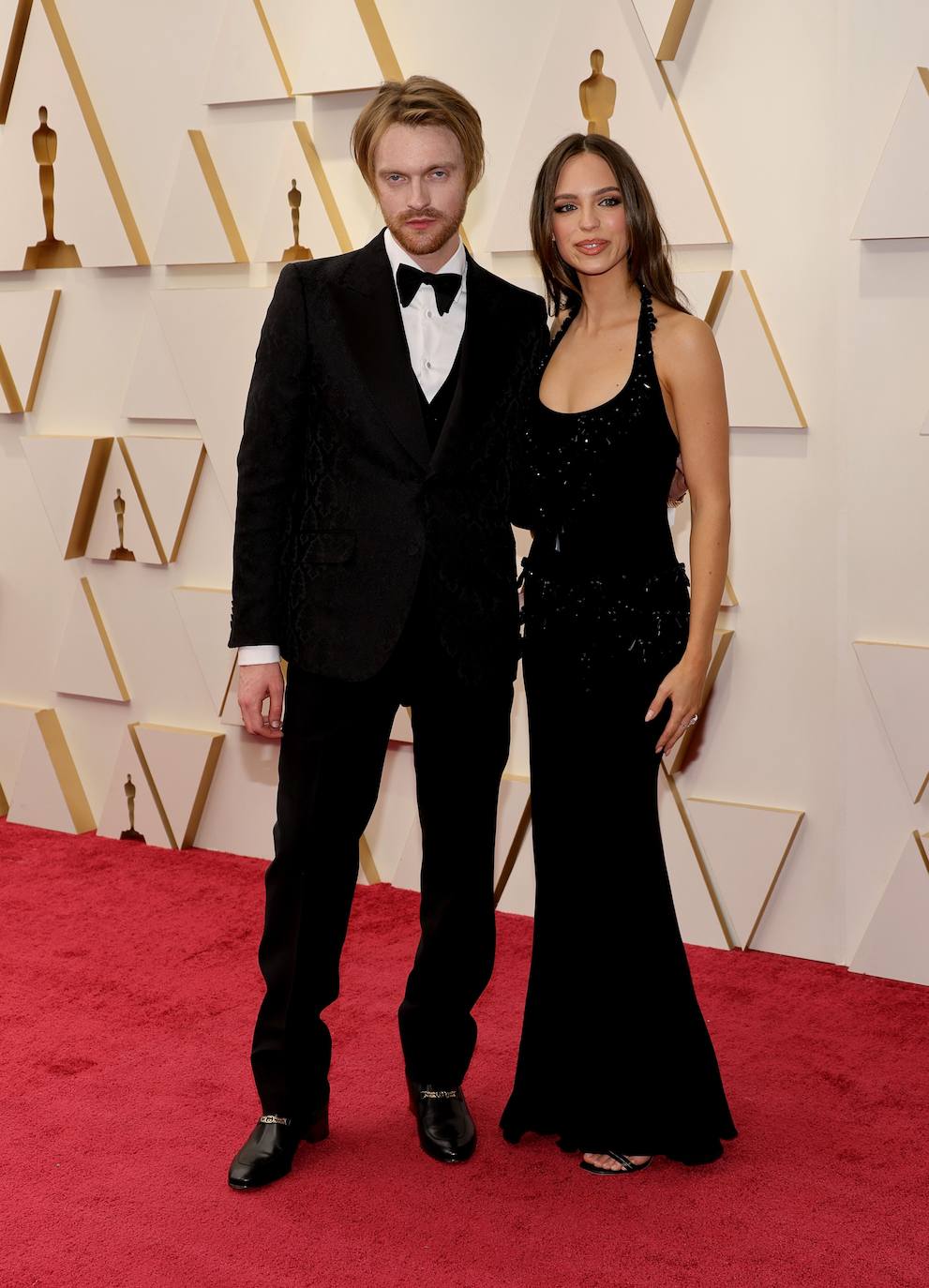 Finneas, con esmoquin negro, y Claudia Sulewski, con un vestido negro con escote 'halter', pedrería y plumas, han llegado de lo más compenetrados al 'photocall'