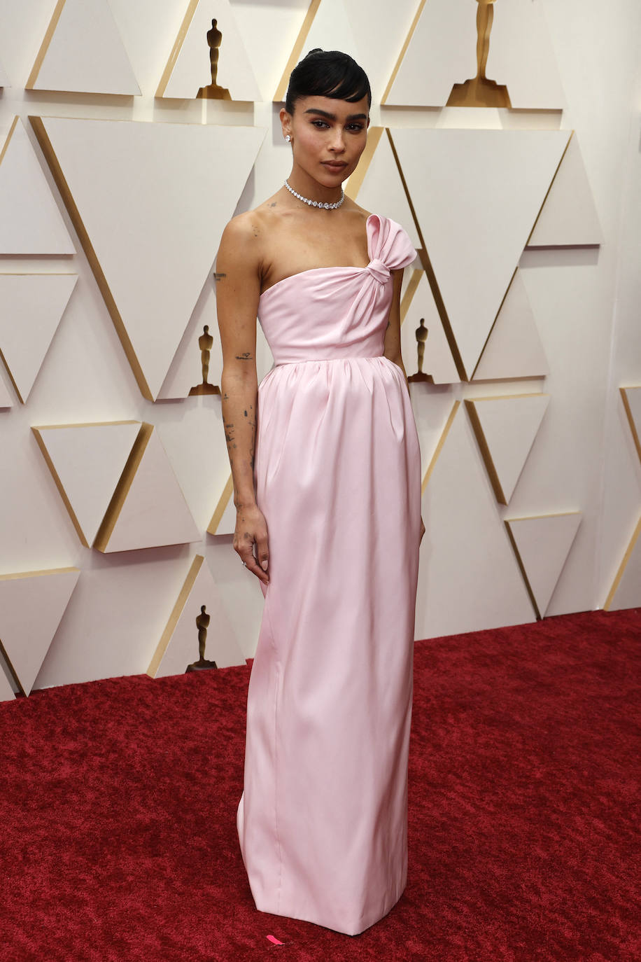 Zoe Kravitz ha deslumbrado con este delicado, elegante y romántico vestido rosa pastel, palabra de honor y con lazo de Saint Laurent. Ha sido una de las protagonistas de la retransmisión de la alfombra roja