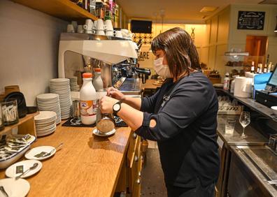 Imagen secundaria 1 - Un empleado del bar Baluarte Donostia coloca unos refrescos. Nagore Abaigar prepara un café en el bar Xare de Tolosa. El bar de la Hípica de Loiola anuncia la subida temporal de precios en su carta de productos. 