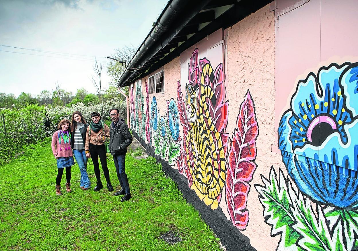 La artista Juncal Alfonso, la coordinadora de los haurtxokos, Nerea Gascón, la autora del mural, Cristina Júndiz y el delegado de Juventud, Santi Jiménez, junto a la fachada trasera de 'El Rancho'. 