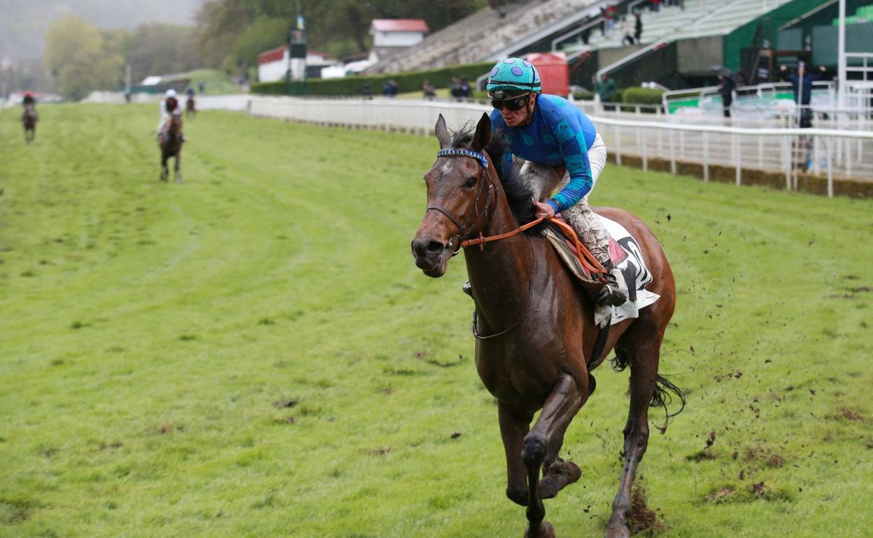 'Idole Royale', montado por Nico de Julián, tras pasar el espejo de ganadores en una embarrada pista. 