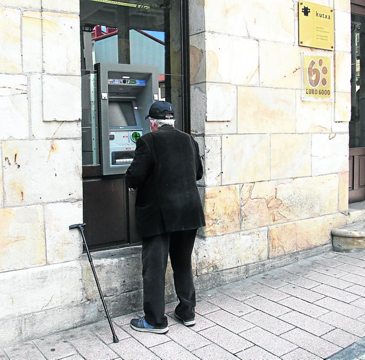 Una persona mayor afronta una operación en un cajero automático. 