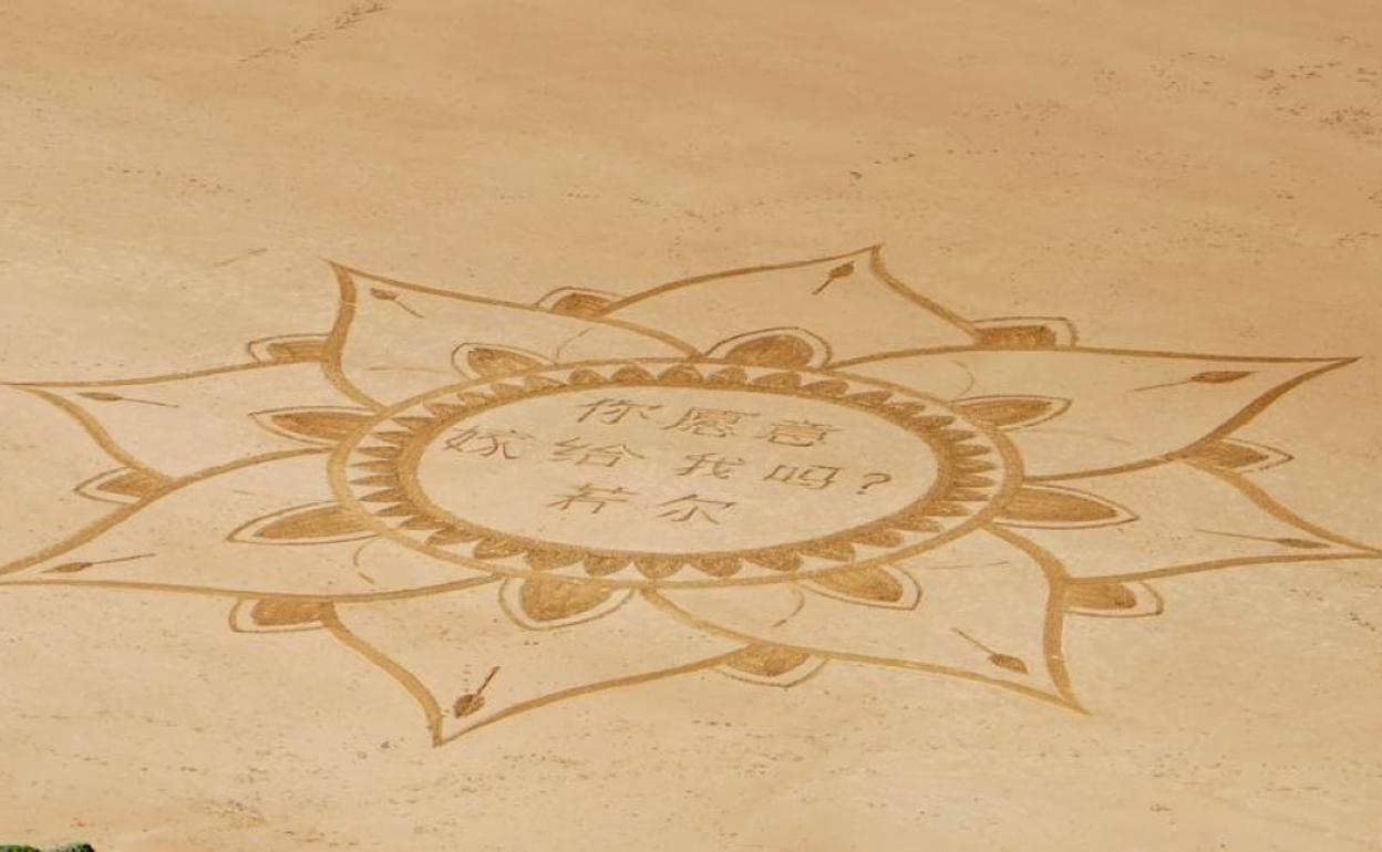 La petición de matromonio dibujada en la arena de la playa de Biarritz.