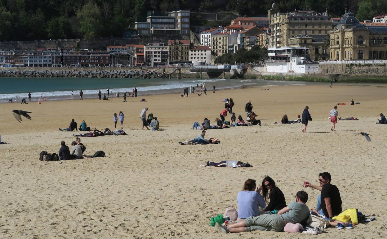 El buen tiempo ha animado a relajarse en la playa de La Concha.