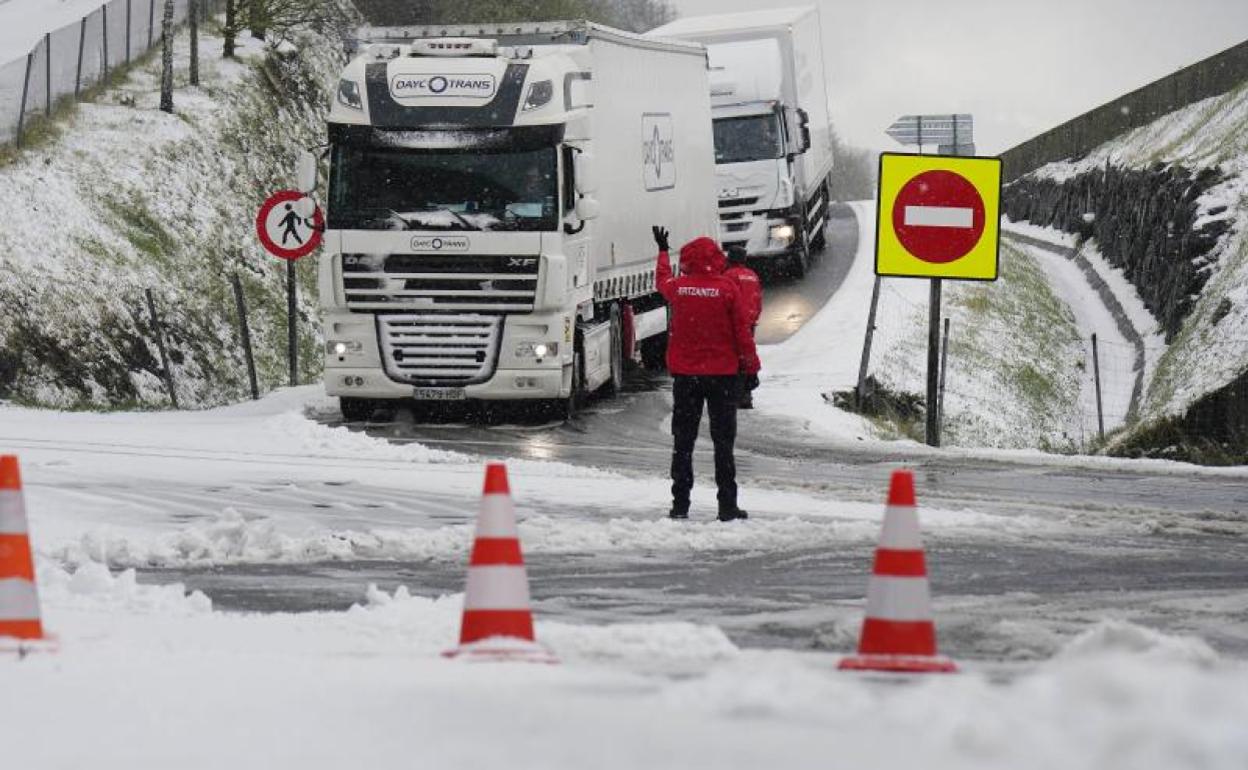 Un ertzaina da indicaciones a un camión a la altura de Berastegi el pasado 1 de abril, con la A-15 cortada. 