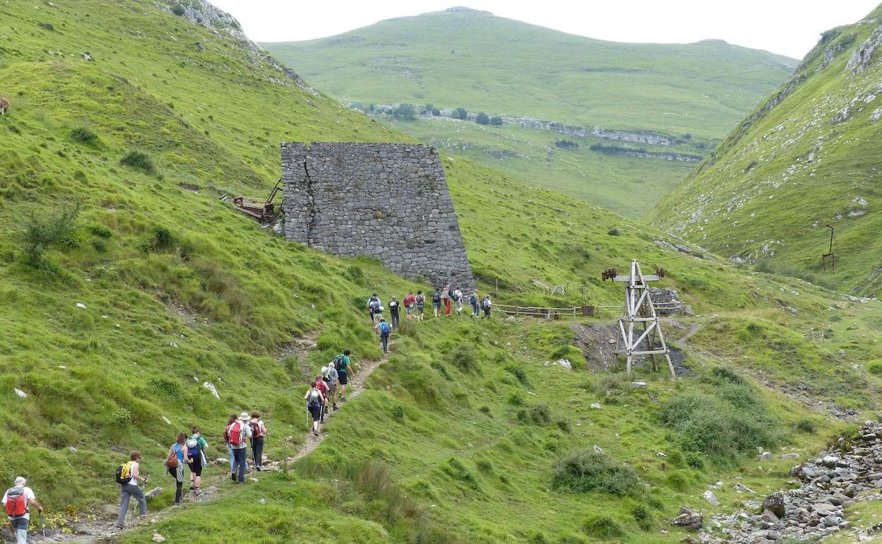 Senderistas caminan junto a los restos de las minas de Buruntzuntzin en el valle amezketarra de Arritzaga