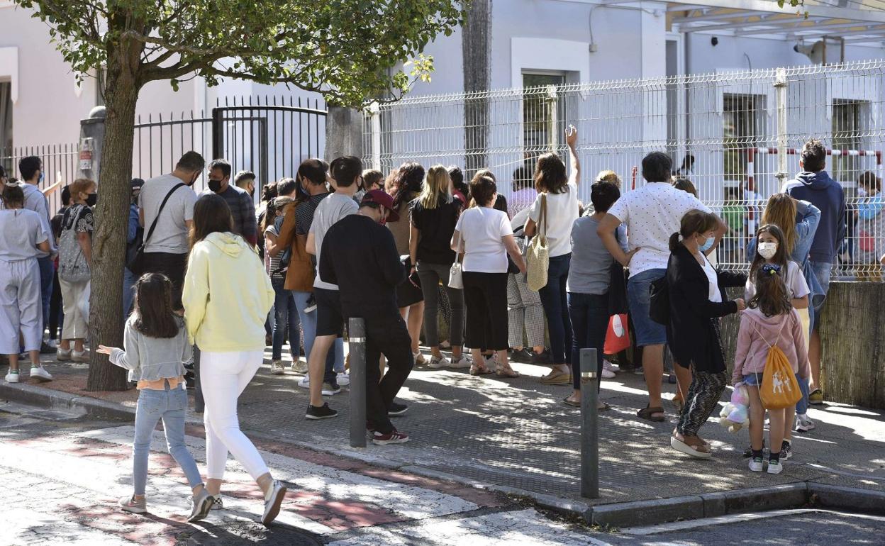 La hora de salida de un centro escolar congrega a sus padres en la entrada.p