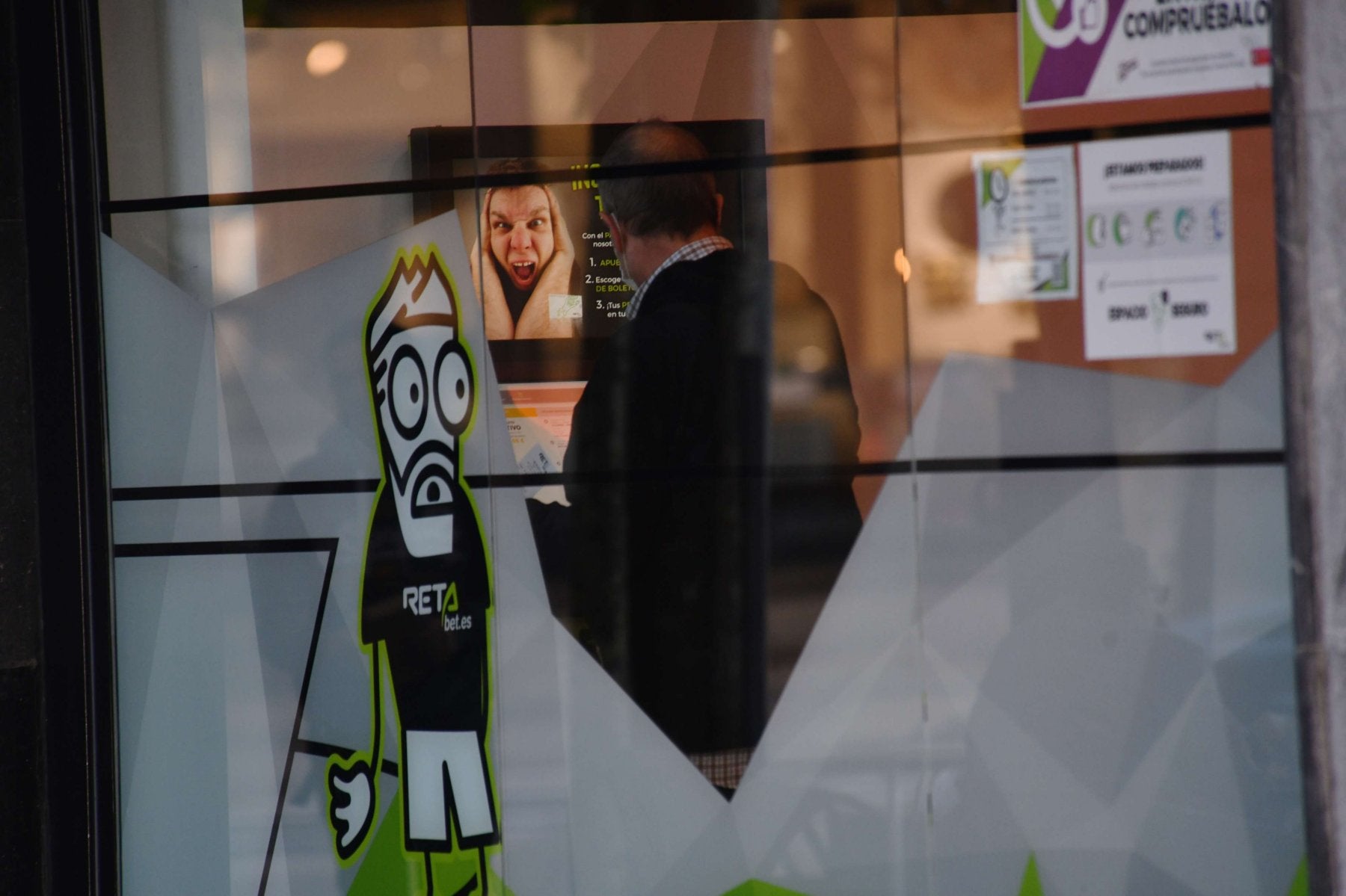 Un hombre observa una pantalla en una casa de apuestas de San Sebastián. 