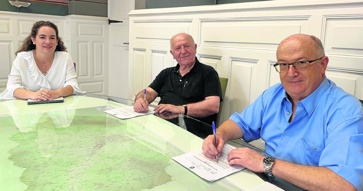 El alcalde y el párroco en la firma, acompañados de la concejala. 