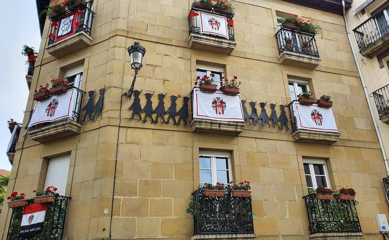 Decoración sanmarcialera con varias banderas en la fachada de un edificio de la Parte Vieja. 
