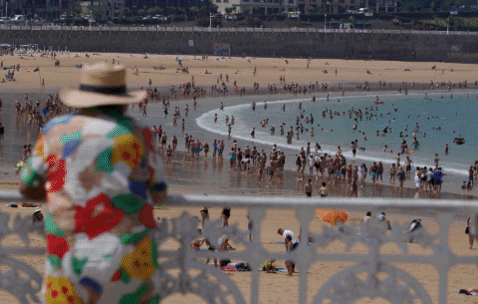 Una mujer y dos niños juegan en una fuente de Arrasate para aliviar el calor. p