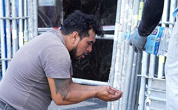 Jose se refresca con agua en una obra de Donostia. 