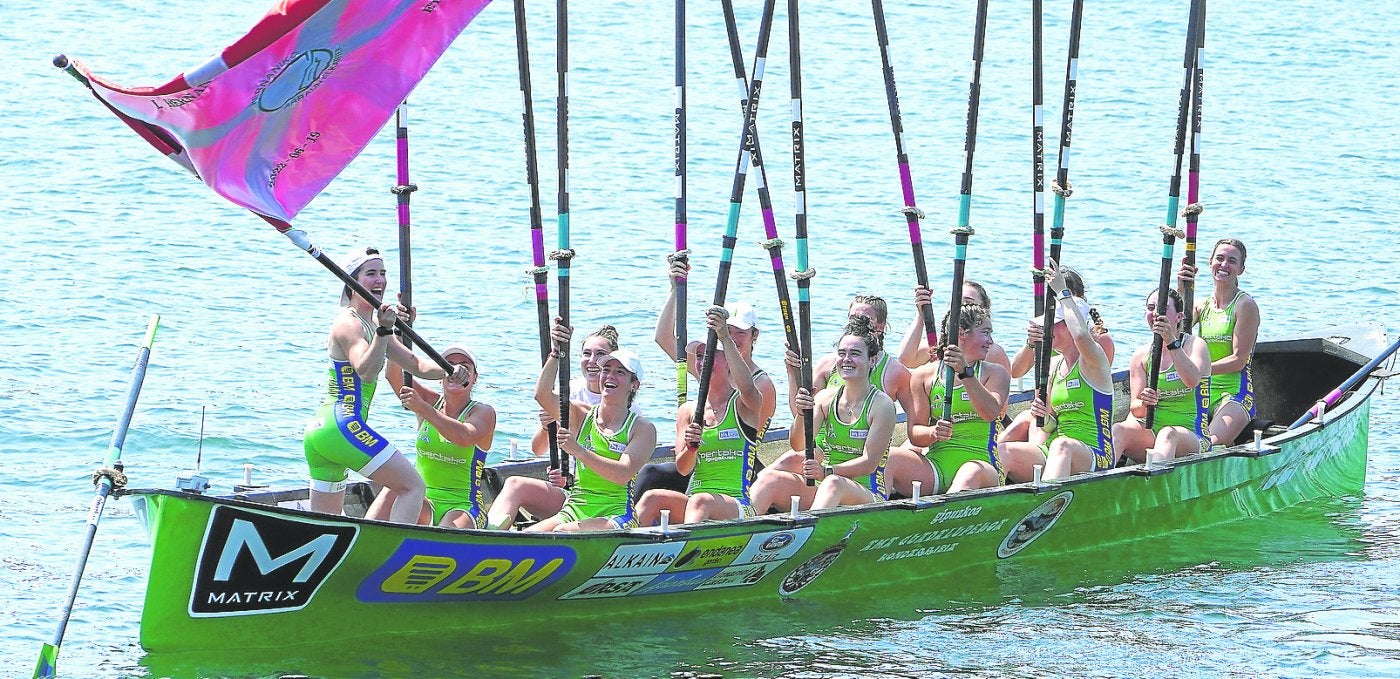 La patrona de Hondarribia, Miren Garmendia, ondea la bandera mientras las remeras levantan sus remos en señal de victoria este domingo en Pasaia. 
