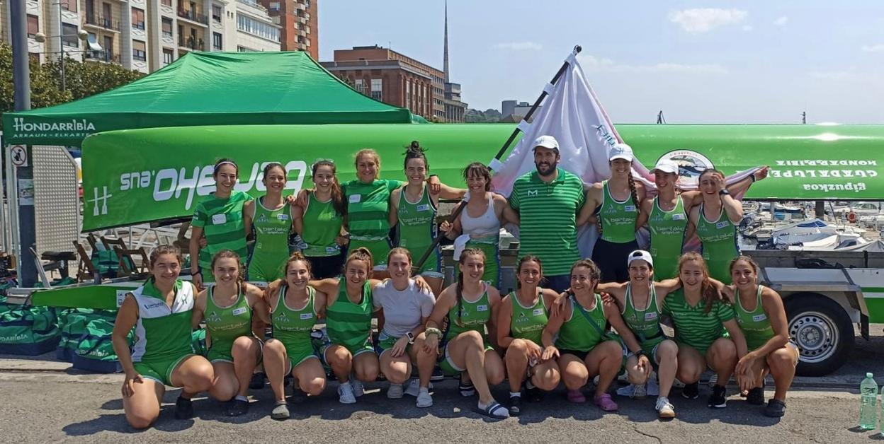 Las remeras de la Ama Guadalupekoa y el entrenador Iker Cortés posan con la bandera de Hernani conquistada en aguas pasaitarras.