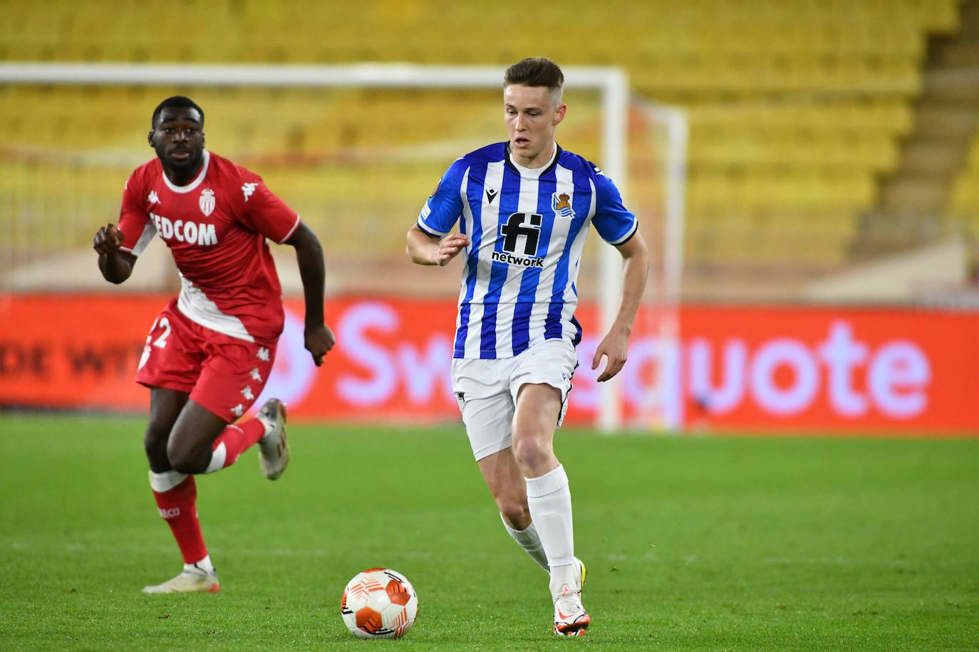 Beñat Turrientes conduce el balón perseguido por un jugador del Mónaco en un partido correspondiente a la fase de grupos de la Europa League disputado en el Louis II. 