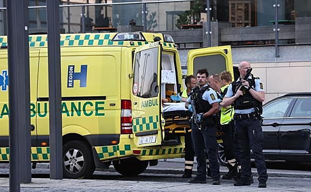 Policías custodian una ambulancia que se dispone a evacuar a un herido.