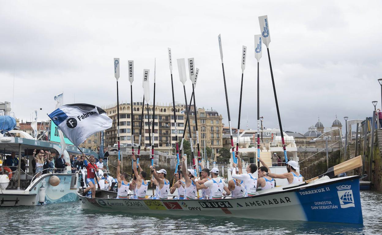 Los remeros de Donostiarra levantan los remos tras ganar la Bandera Fabrika. 