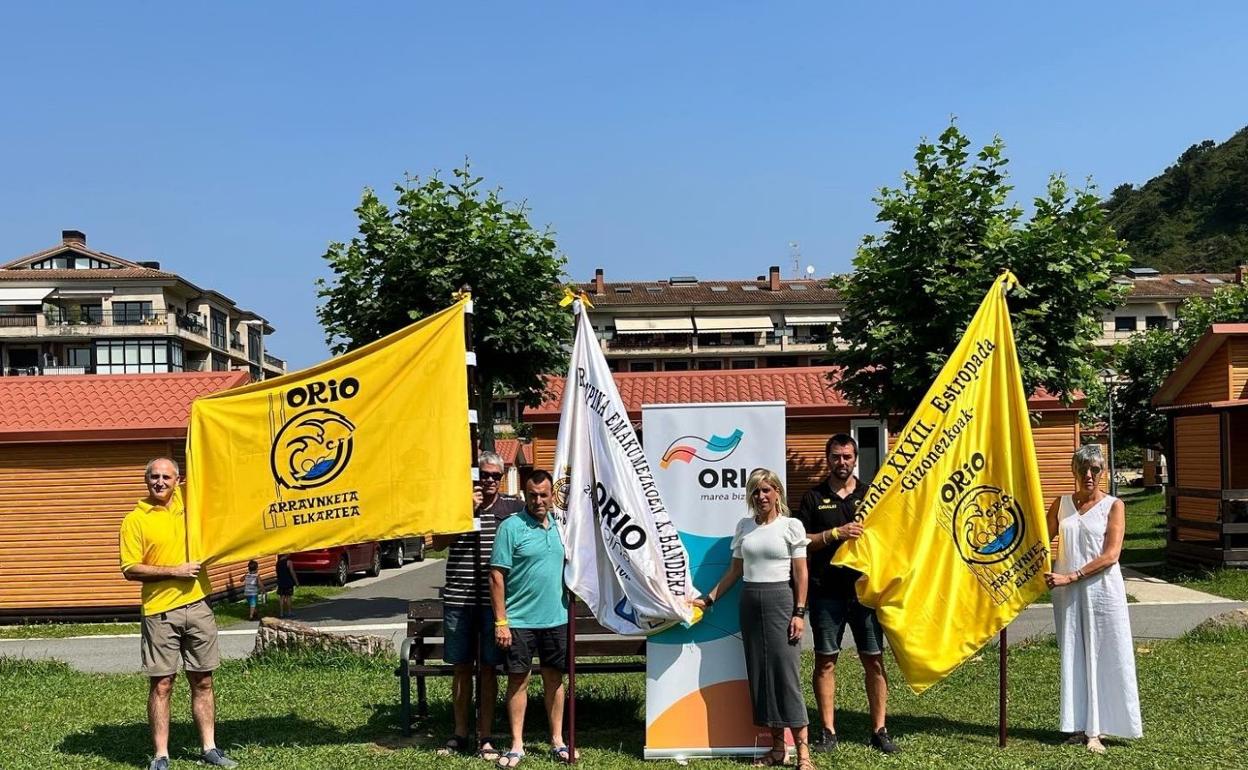 Autoridades y miembros de Orio Arraun Elkartea posan con las banderas que se ponen en juego. 