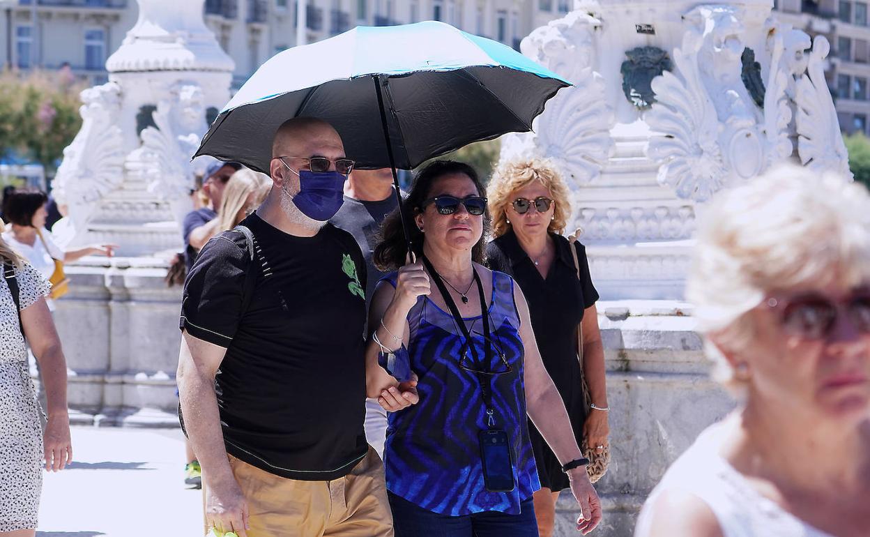 Veraneantes se resguardan del sol en Donostia. 
