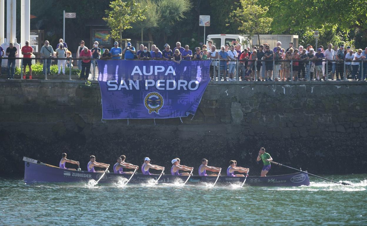 La Libia de San Pedro remando en la bahía mientras sus aficionados le aplauden. 