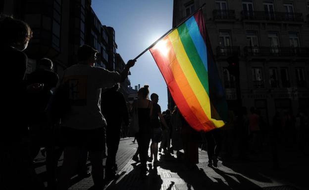 Varios jóvenes pasean con la bandera arcoíris por las calles de Vitoria.