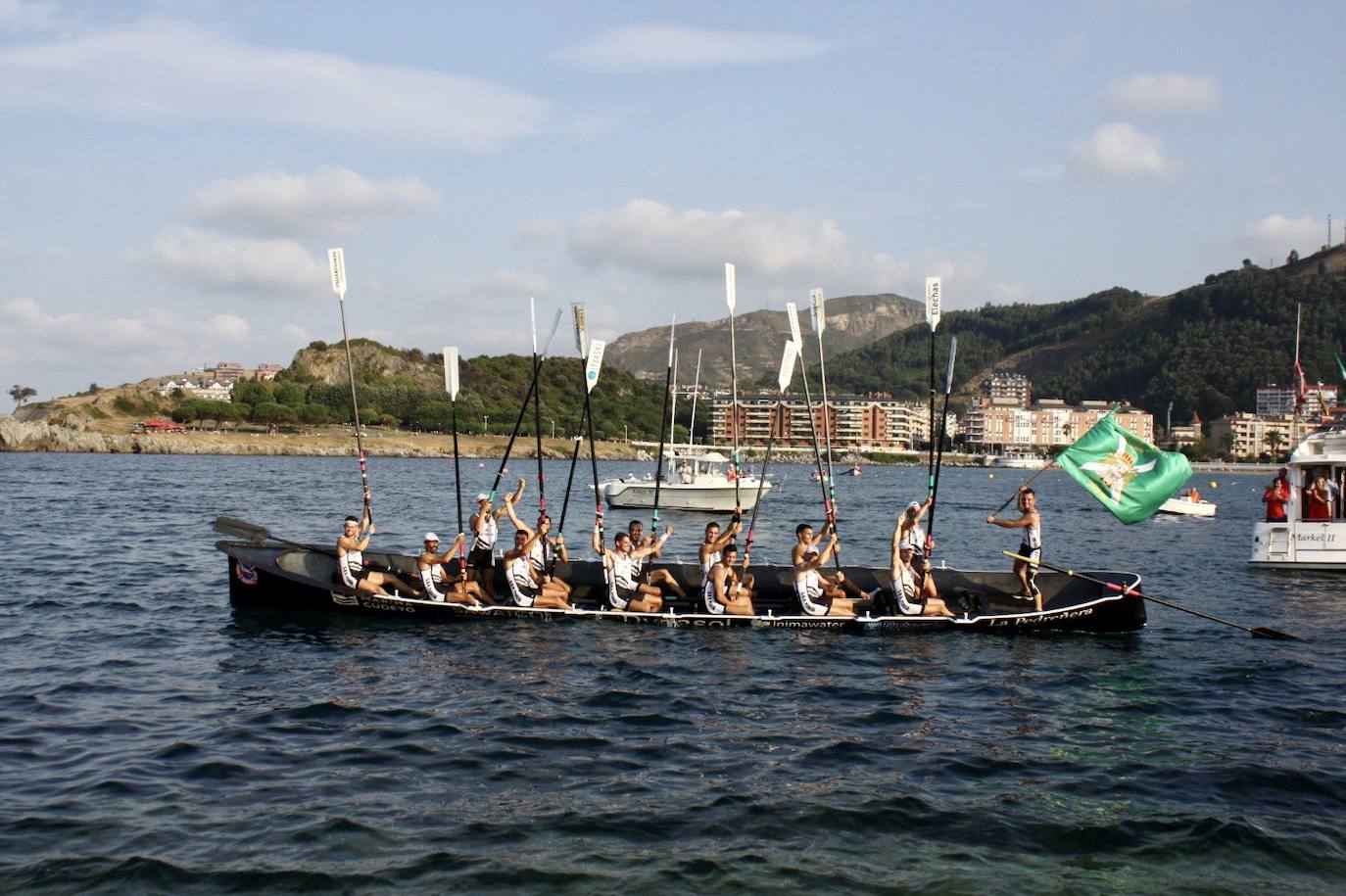 Los remeros de Pedreña levantan los remos tras imponerse en Castro. 