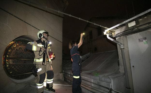 La directora, Elisabeth Arrillaga, ilumina a un bombero una zona del tejado del Ayuntamiento. 