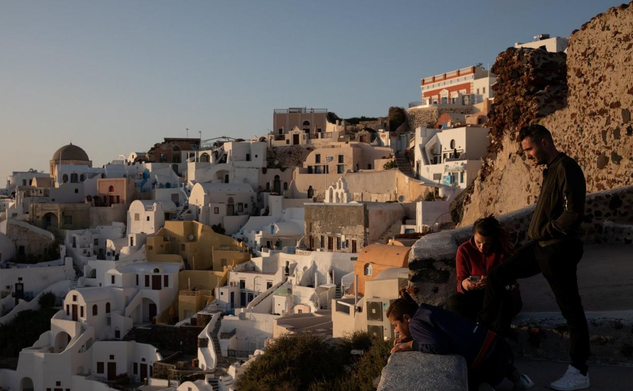 Tres turistas observan la puesta de sol en Santorini, donde estaba de vacaciones el joven agredido. 