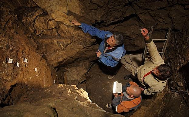 Tres científicos trabajando en la cámare este de la cueva de Denisova.