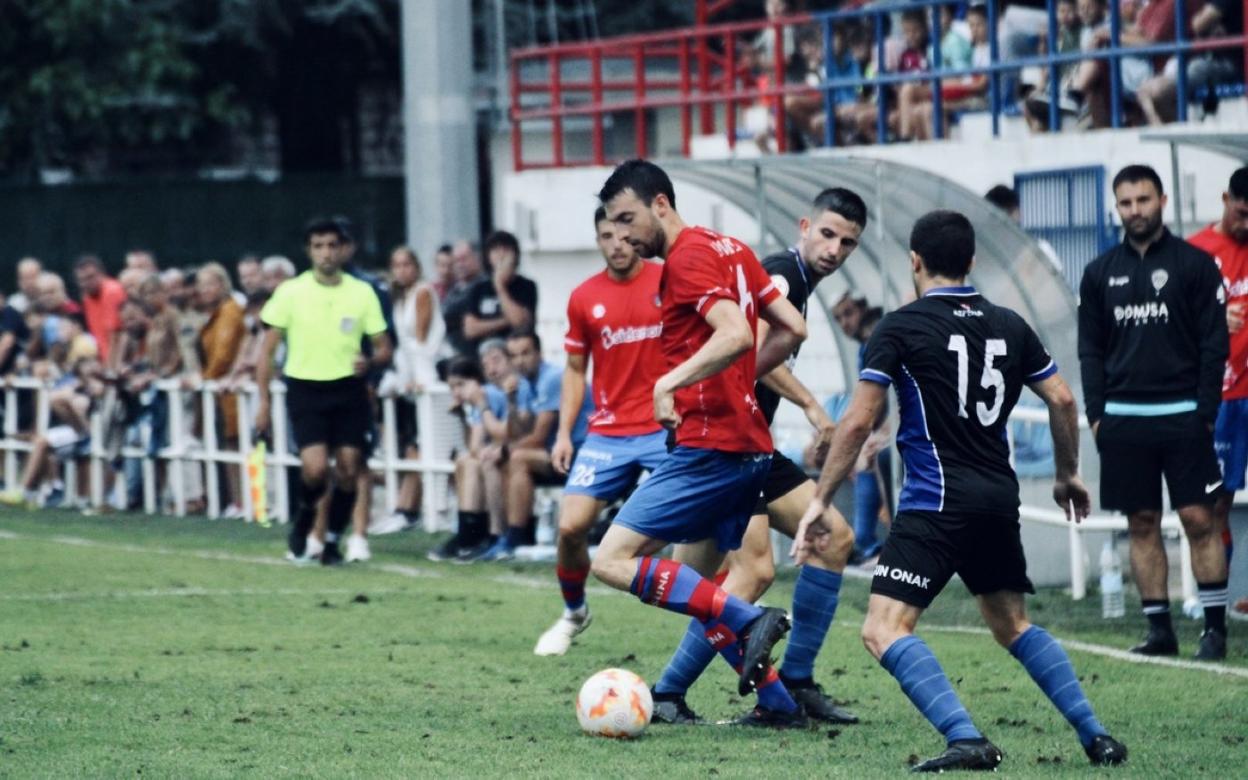 Ander intenta marcharse de dos rivales en el partido disputado ante el Lagun Onak. 