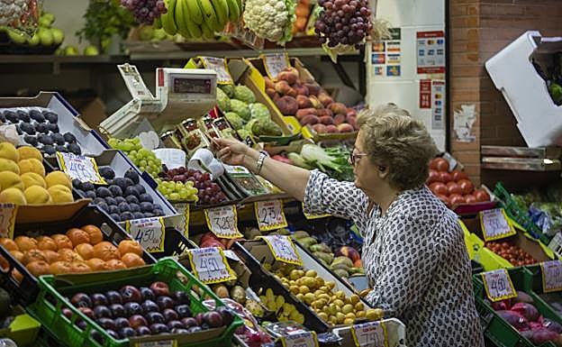 Una mujer se dispone a pagar en una frutería. 