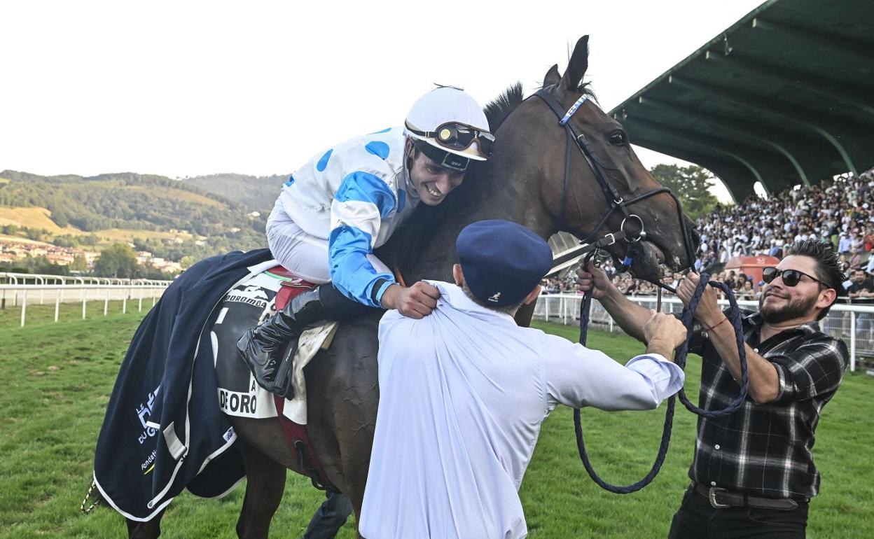 El jockey luso Ricardo Sousa Ferreira saluda a uno de los propietarios de 'Il Decamerone' en plena pista tras ganar la Copa de Oro. 