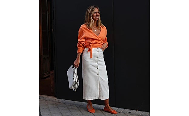 Lucia Barcena con look en tonos naranjas y blancos.