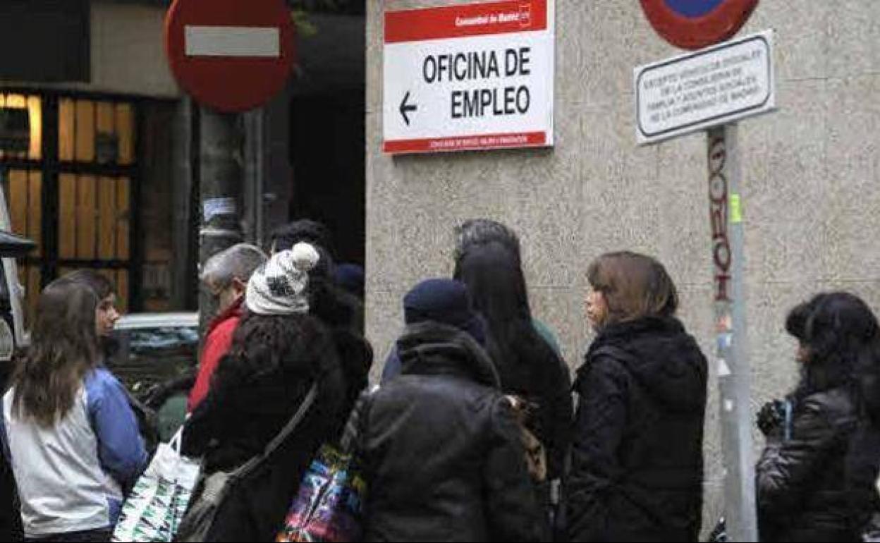 Un grupo de personas hace cola en una oficina de empleo.