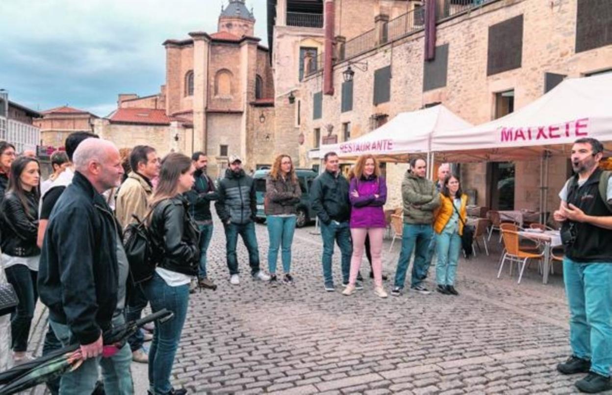 Turistas atienden explicaciones en la plaza del Machete. 