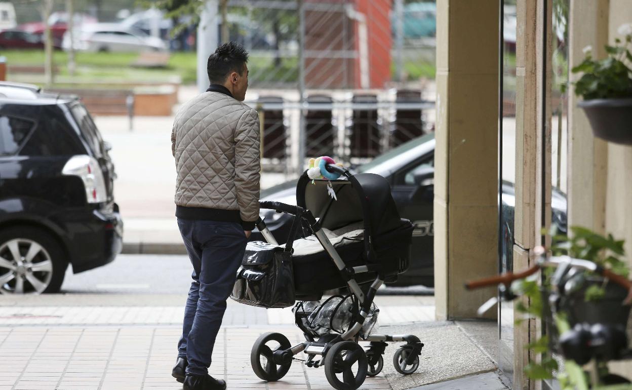 Un padre empuja un carrito de bebé por Donostia.
