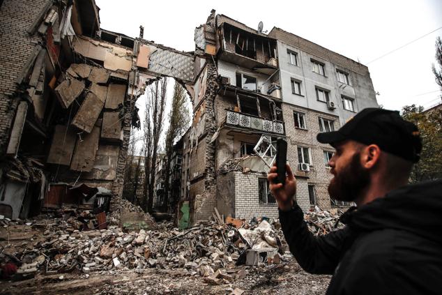 11 de noviembre de 2022, Mykolaiv, Ucrania, próxima a la ciudad de Jersón. Un hombre toma fotos de un edificio residencial de 5 plantas que fue alcanzado por un misil ruso S-300.