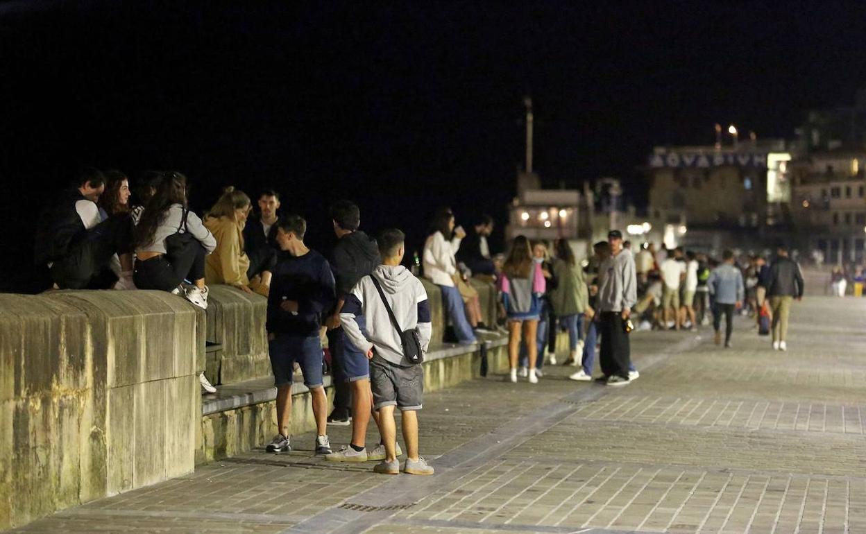 Varios jóvenes se concentran por la noche en el muelle donostiarra. 