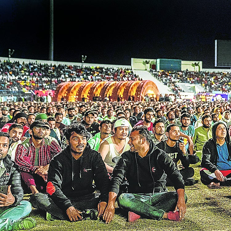 Trabajadores durante el partido Inglaterra-Senegal, en un estadio de criquet que les sirve de 'fan zone' un suburbio industrial en Doha. 
