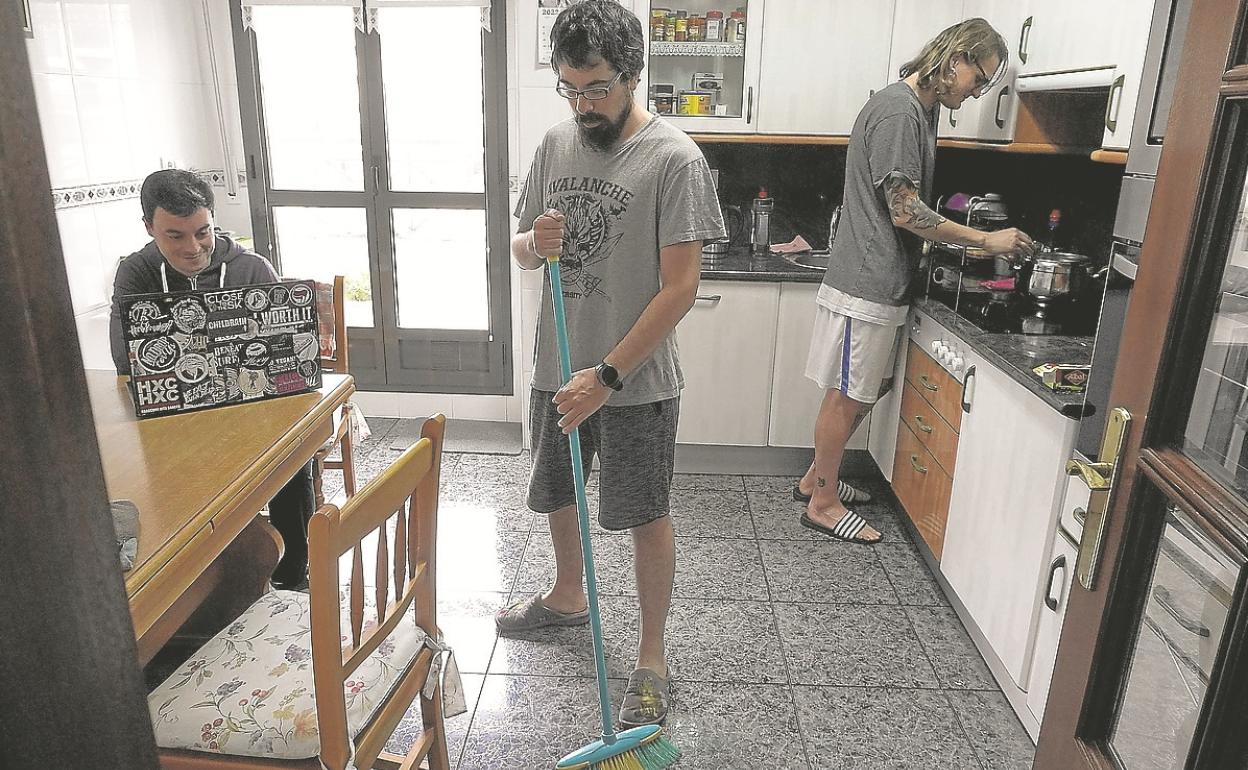 Tres jóvenes que residen en un piso de alquiler de Lasarte-Oria, en la cocina de su casa. 