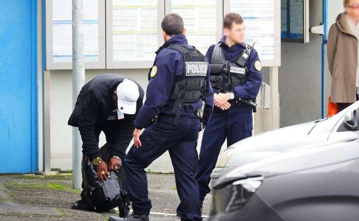 Dos policías franceses solicitan la documentación a una persona. 