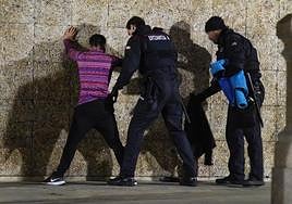 Dos agentes de la Ertaintza realizan un cacheo a un varón en los bajos de La Concha, en Donostia.