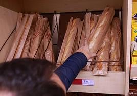 Un hombre compra pan en un supermercado.