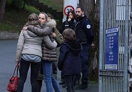 Dos madres se abrazan en la entrada al liceo Santo Tomás de Aquino, de San Juan de Luz.