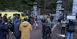 Un coche de la Policía sale del centro escolar de San Juan de Luz con varios alumnos esperando fuera.
