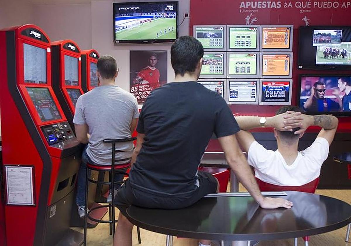 Unos jóvenes en un salón de apuestas.